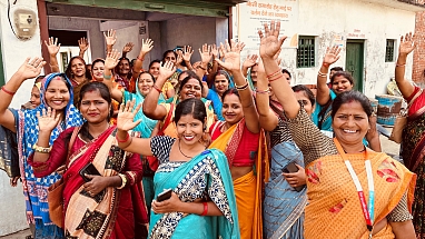 Participants of the Shubh Mint program smile and wave in a joyful group photo.