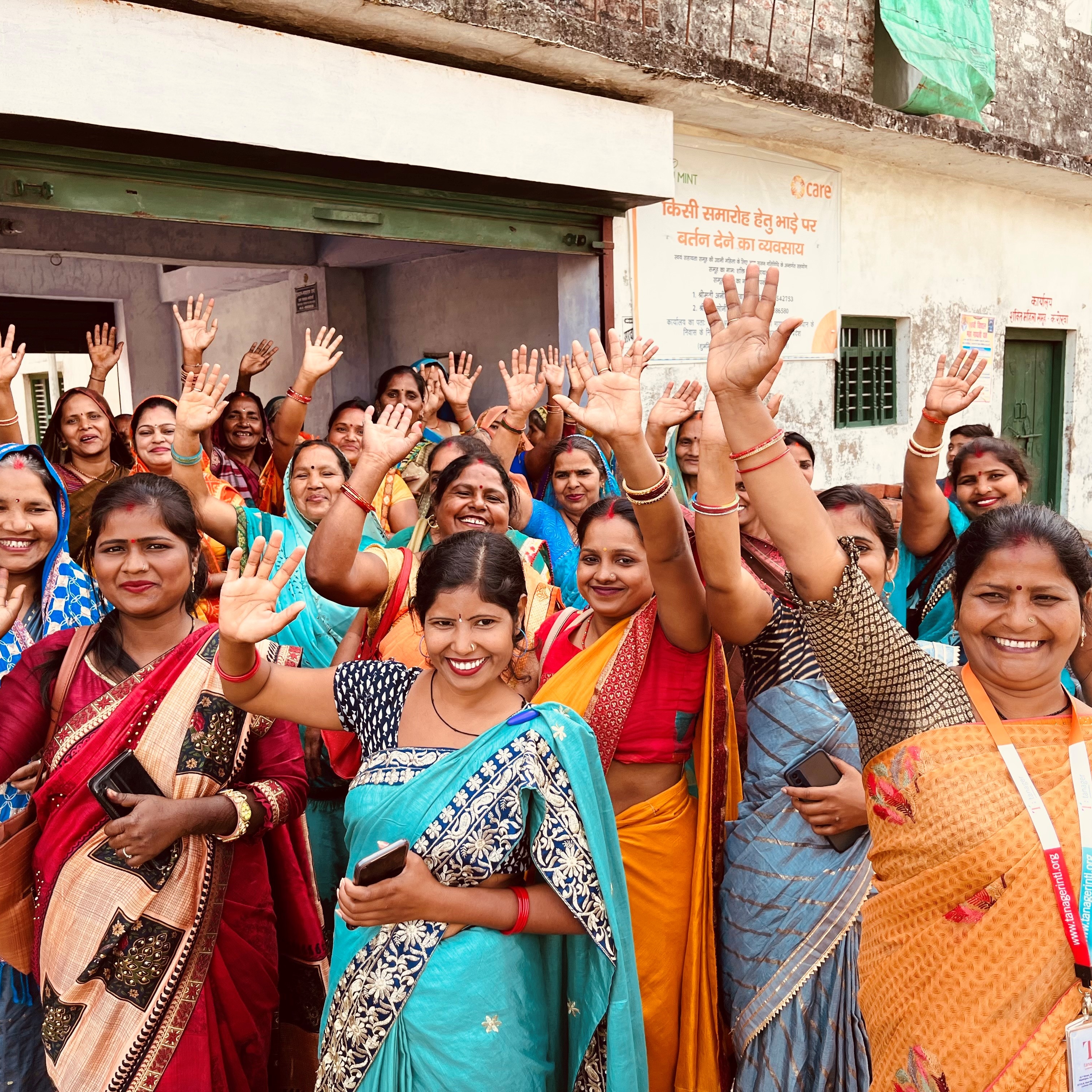 Participants of the Shubh Mint program smile and wave in a joyful group photo.