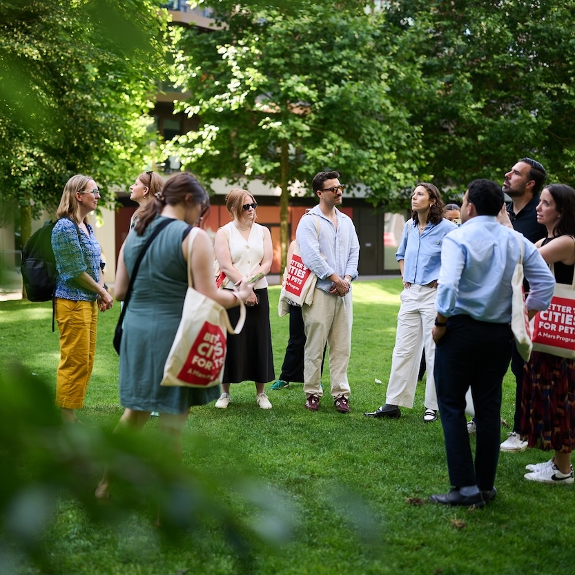 People gathering in the grass at Kings Cross, London.